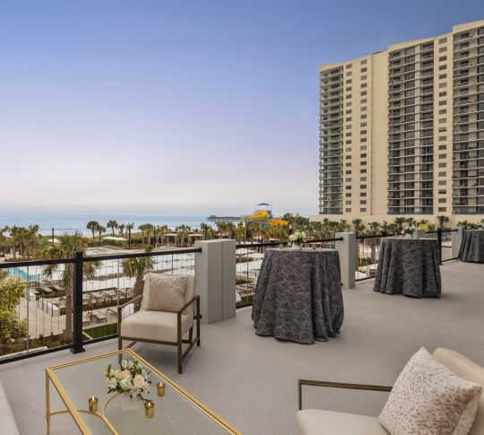 Spacious outdoor ballroom balcony featuring comfortable seating and ocean view-transition