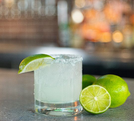 มาร์การิตาพร้อมไลม์บนโต๊ะสําหรับโครงการ Happy Hour Austin Taco