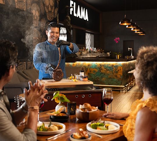 在 Flama Restaurant 的桌上檢查向情侶送餐