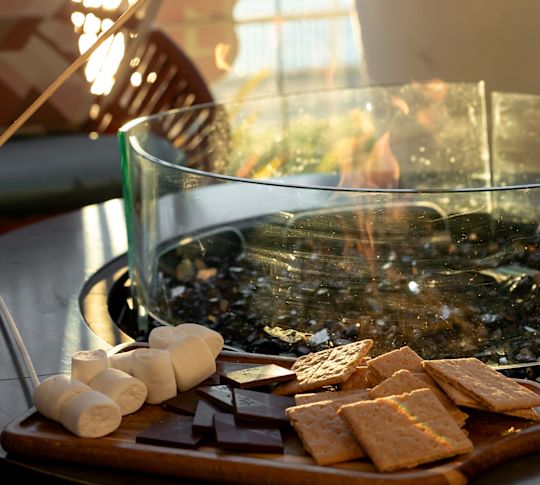 O persoană care ține un Marshmallow în foc pentru a face mai multe lucruri