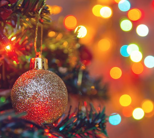 holiday tree with a gold ornament and lights