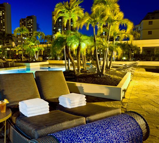 Lounge chairs by the pool at night