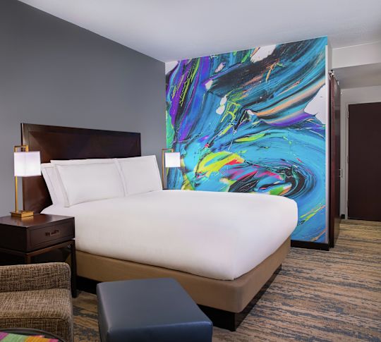 Bed in room with chair and lamps