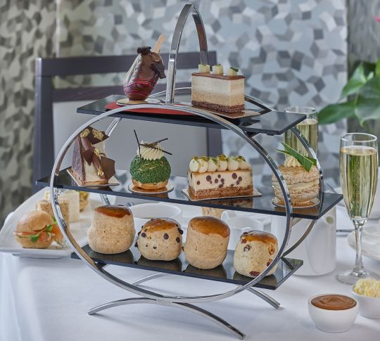 Traditional afternoon tea serving tray with cakes on it