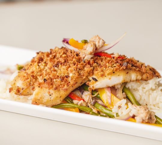 盘中有裹有面包屑的鱼，配以米饭和蔬菜