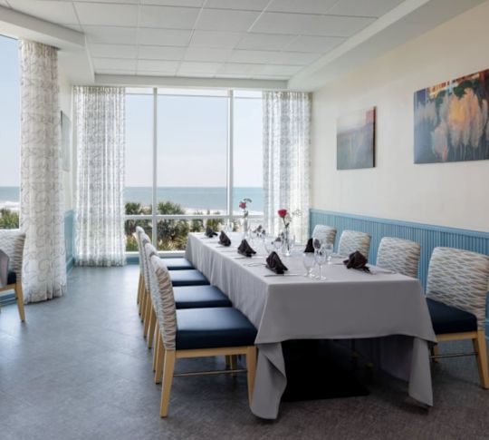 Coin repas du restaurant PDR avec vue sur l'océan