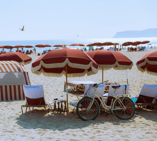 Beach scene with umbrellas, bike and beach chairs