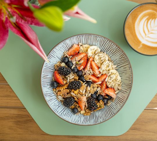 room service, fruit and cereal bowl, latte with design in the foam-transition