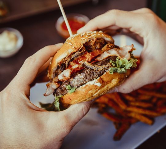 Closeup of a hand holding a burger