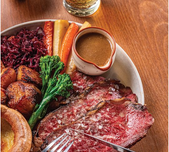 Roast Meat on a Plate with Vegetables and Sauce at Jones the Grocer