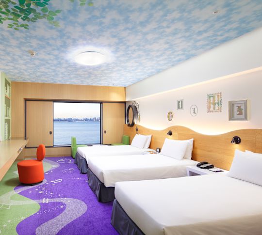 Happy Magic-rum med tre enkelsängar, TV och fönster med havsutsikt