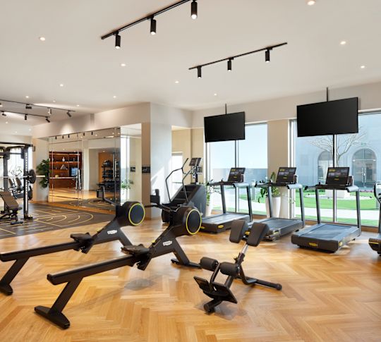 TVs, Treadmills and other Equipment in Fitness Center with Large Windows