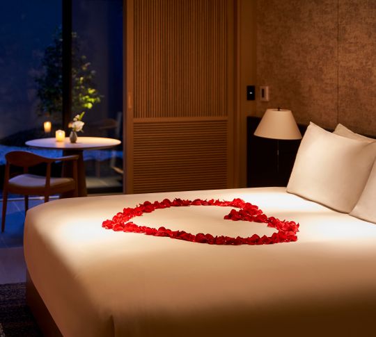 guestroom bed with rose petals in shape of heart