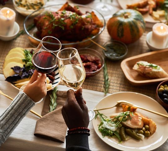 couple tenant des verres de vin à côté de la nourriture