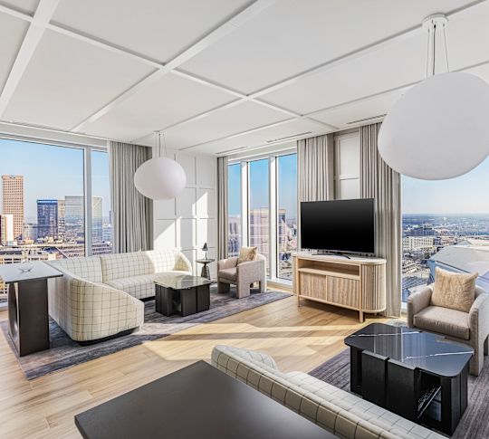 Guestroom lounge area with sofas, tables and TV