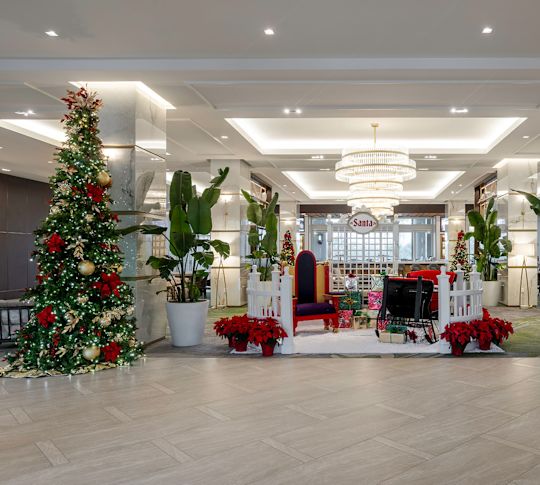 Lobby mit Weihnachtsbäumen und Poinsettien für die Feiertage