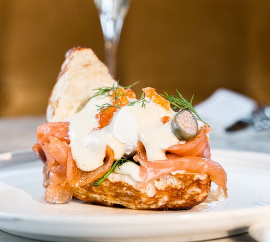 Ein Teller mit Speisen und Getränke auf einem Tisch bei Champagne & Eggs im ROCA Restaurant