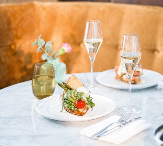 Speisen und Getränke auf einem gedeckten Tisch bei Champagne & Eggs im ROCA Restaurant