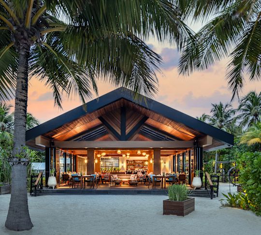 Exterior View of the The Ledge Restaurant at Sunset with Palm Trees