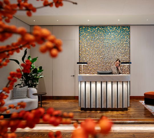 Frau am Telefon im Concierge Desk-Bereich
