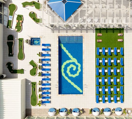 arial view of the pool, hot tub, lounge chairs, mini golf course