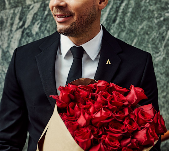 Man in suit holding bouquet of flowers