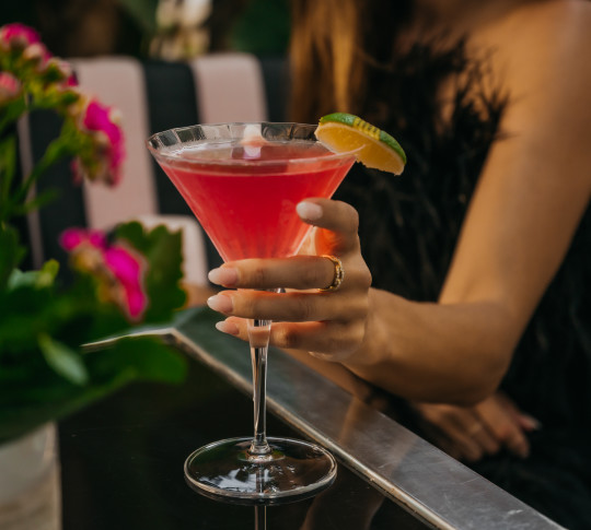 Woman with hand on cocktail