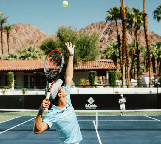 Tennis player serving a ball