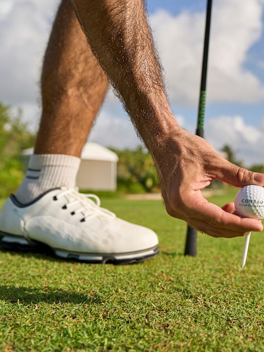 Man placing a golf ball on tee