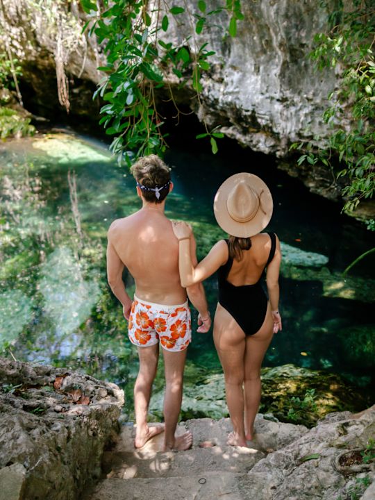 muž a žena stojící na skálách s výhledem na vodu
