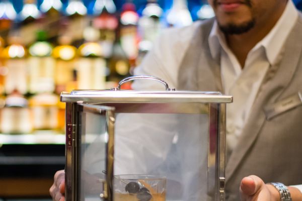 Bartender Holding Case with Cocktail Drink inside steaming