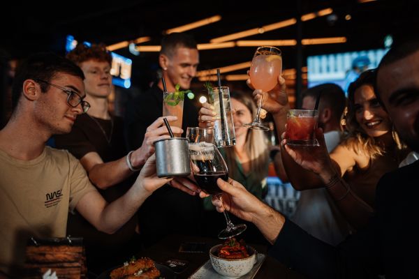 people toasting drinks at a bar