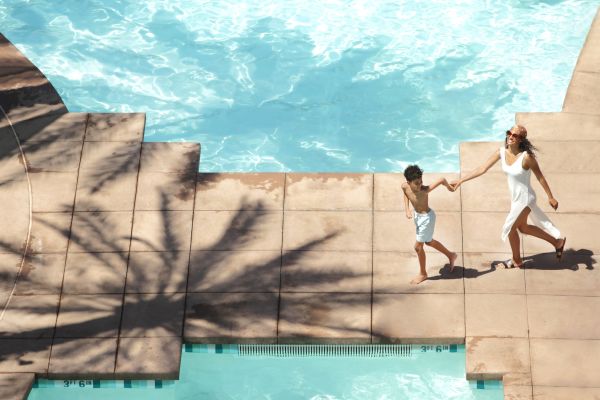 Child pulling woman between 2 pools