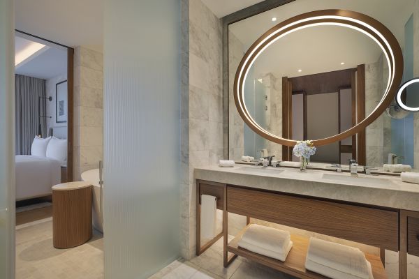 Dual Vanity Area with Round Lit Mirror in a Hotel Suite