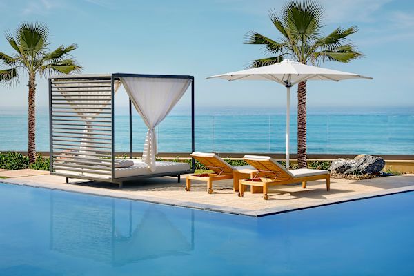 Outdoor pool area with sun loungers and canopy