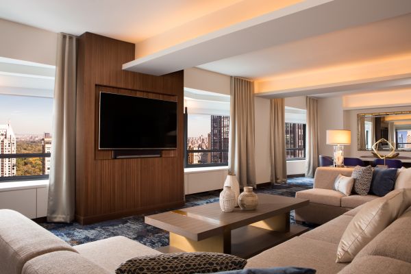 Suite living area with comfortable seating, wall mounted TV and views over the city