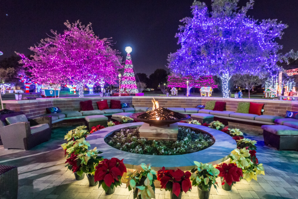 Outdoor seating area with trees decorated with lights in the background