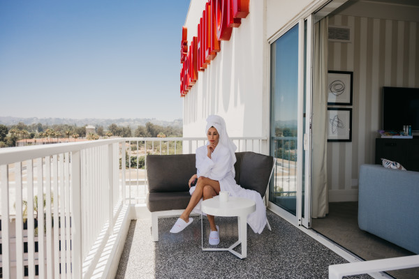 Woman wearing robe sitting on balcony