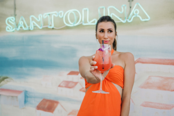 Woman in orange dress holding cocktail