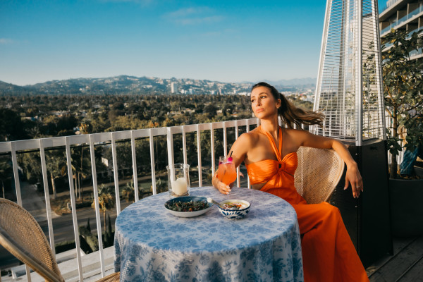 Woman sitting on balcony with cocktail