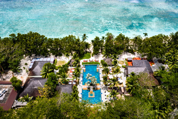 Aerial View of Hotel Exterior with Large Pool Area and View of the Beach