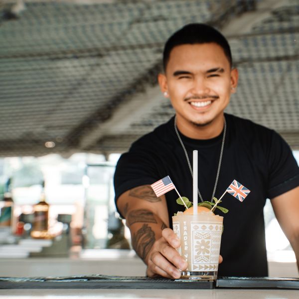 Bartender with cocktail, showing British and US flags