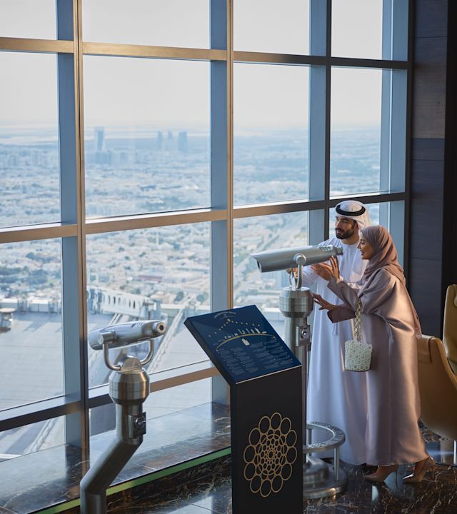 Un homme et une femme sur la terrasse d'observation regardant par le télescope