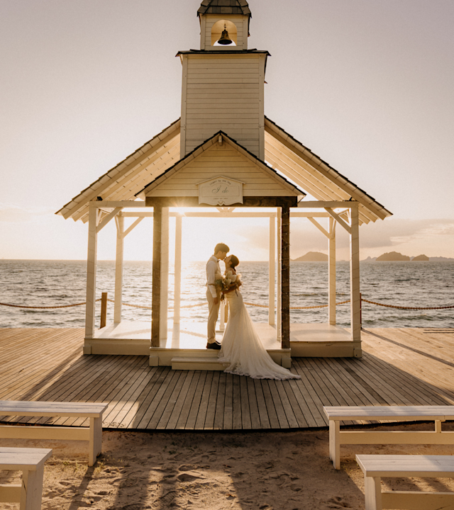 Mireasă și mire sărutându-se pe apă în ziua nunții