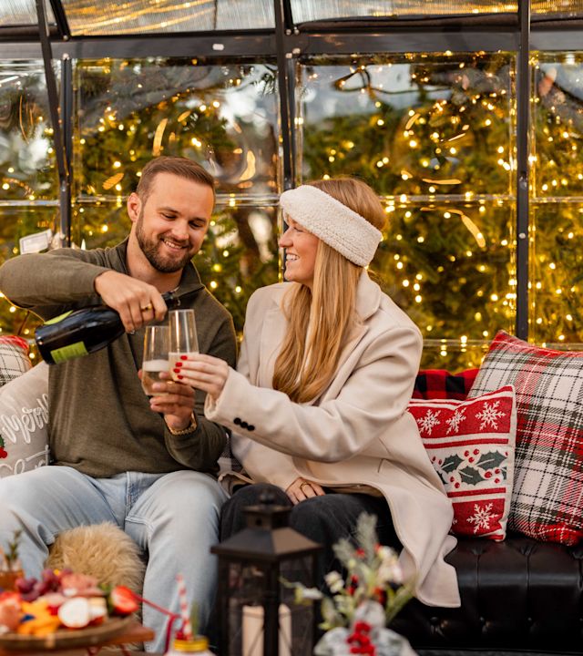 Couple Having Drinks and Snacks in a Cozy Area during the Holidays