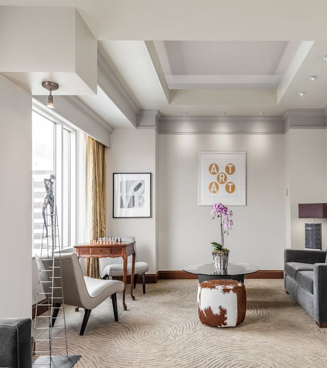 Living room area presidential suite with several seating options and chess board