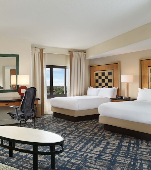 Guestroom with bed, seating area and work desk