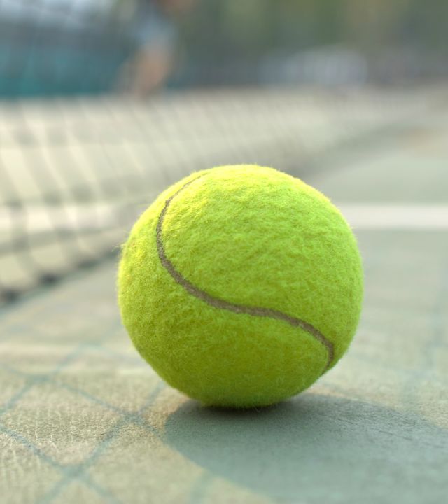 Closeup of tennis ball by net