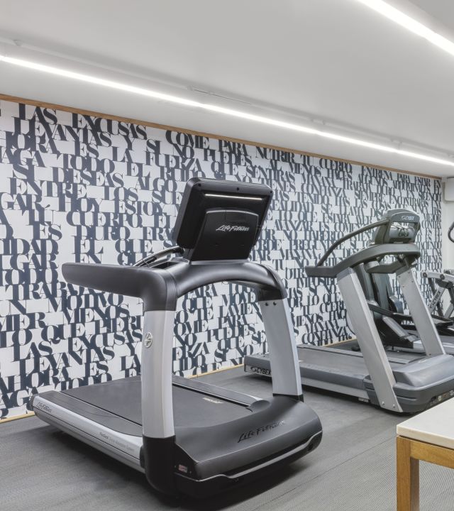 Fitness center treadmill machines with towels on nearby table