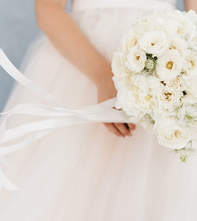 close-up of brides hand holding flowers